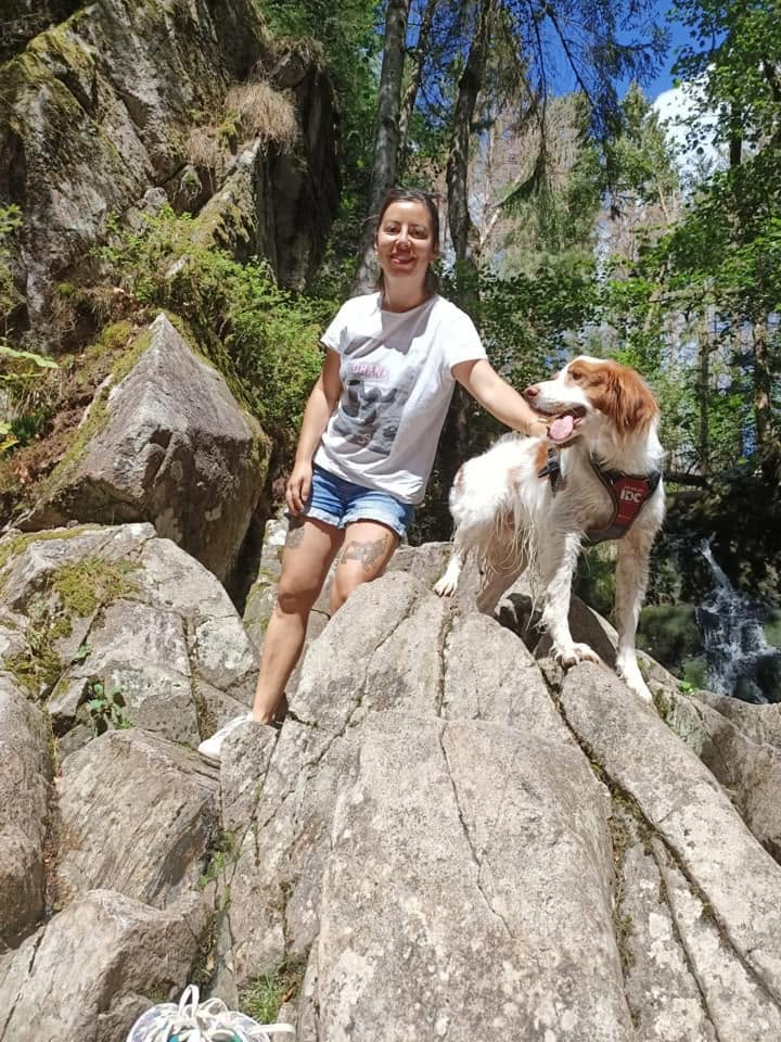 Oriane et son chien sur des rochers en forêt